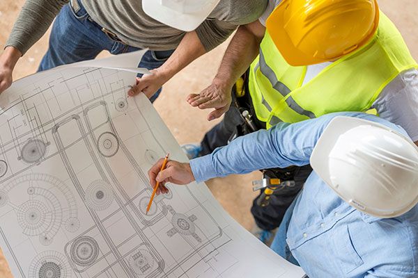 Obreros con planos de obras
